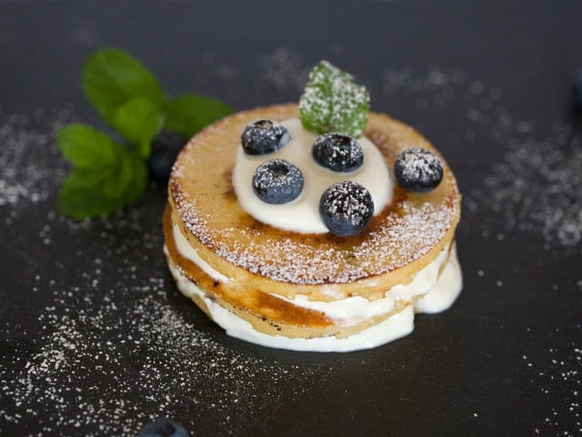 Porridge und Pancakes für ein warmes Geburtstagsfrühstück Pfannkuchen sind ein beliebter Klassiker für ein warmes Frühstück.