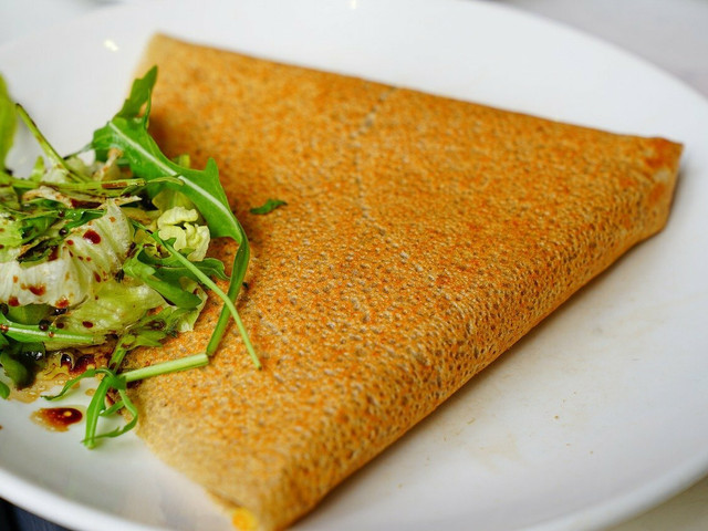 Socca: Einfaches Rezept für die Pfannkuchen Socca aus Kichererbsenmehl - garniert mit etwas frischem Rucola.